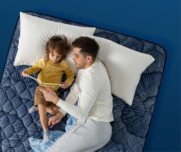 Father and child relaxing on patterned mattress