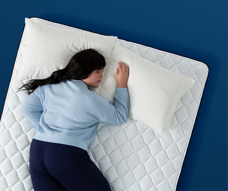 Woman resting on white mattress