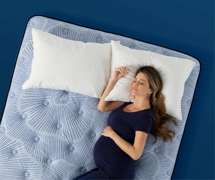 Pregnant woman resting on patterned mattress