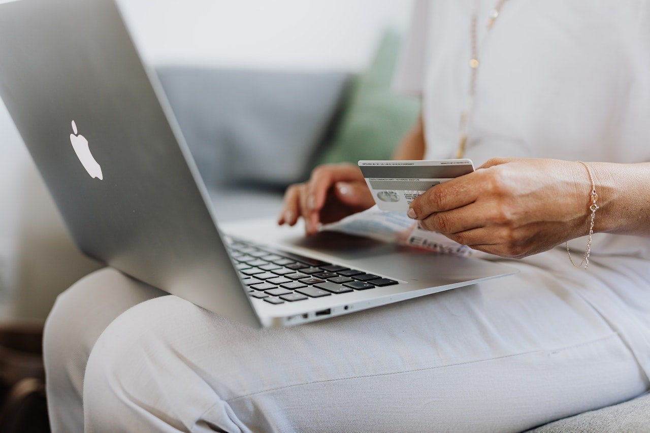 Woman shopping online with laptop and card