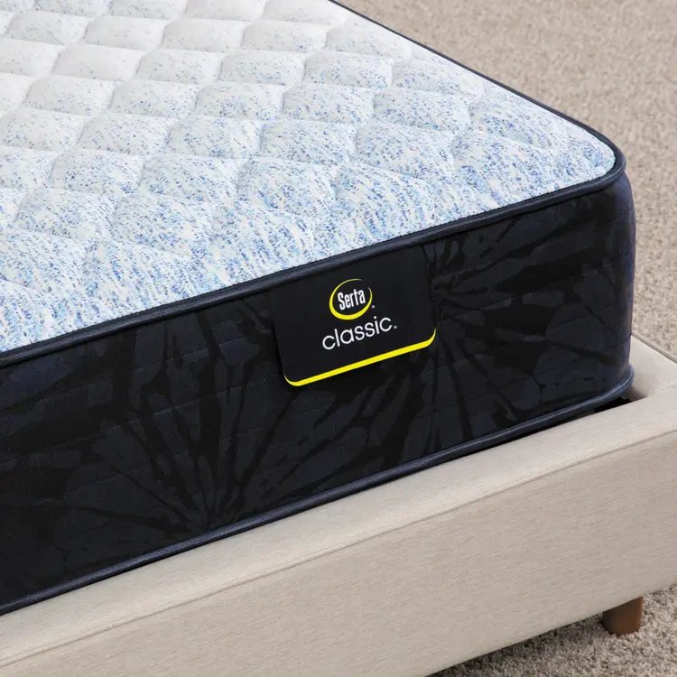 Corner of Serta classic dorian firm mattress sitting in a beige bed frame ||feel: firm ||level: standard